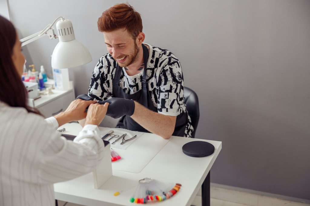 Experienced nail technician working in modern manicure salon
